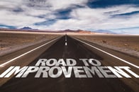 Road to Improvement written on desert road